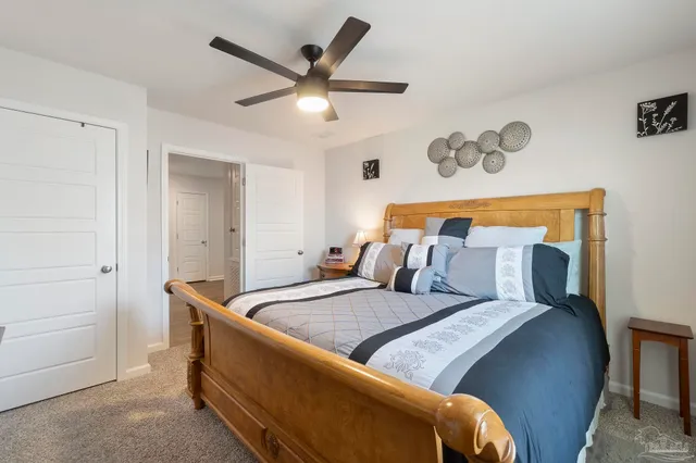 a bedroom with a bed and a ceiling fan