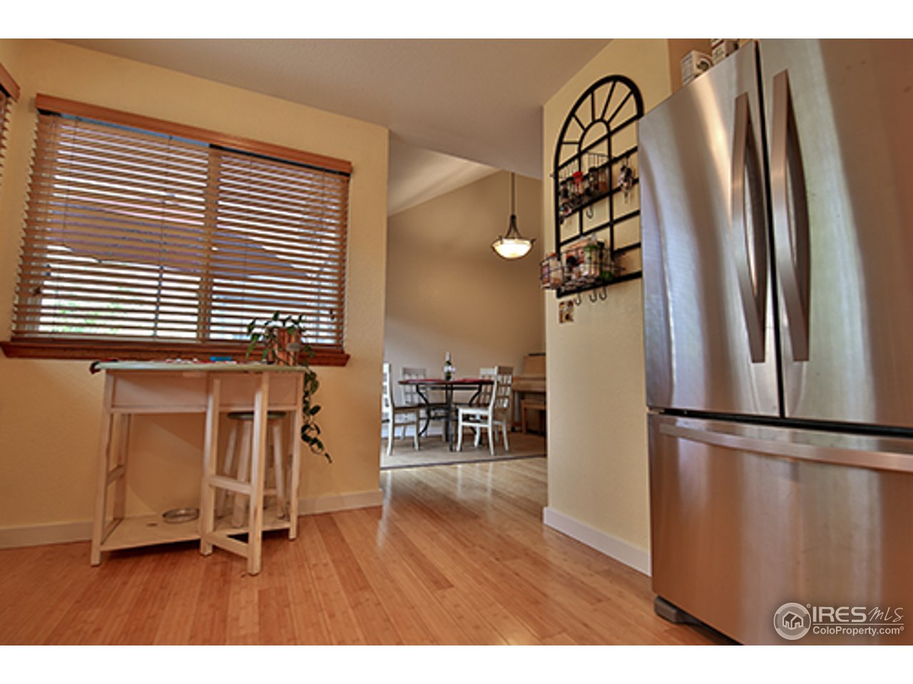 2445 Rim Drive Broomfield, CO 80020 - Photo 3 of 13 a kitchen with stainless steel appliances granite countertop a refrigerator and a wooden floor