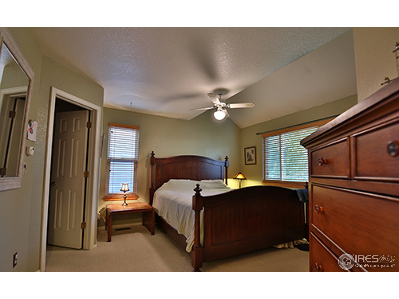 2445 Rim Drive Broomfield, CO 80020 - Photo 6 of 13 a bedroom with a bed lamps and a large mirror