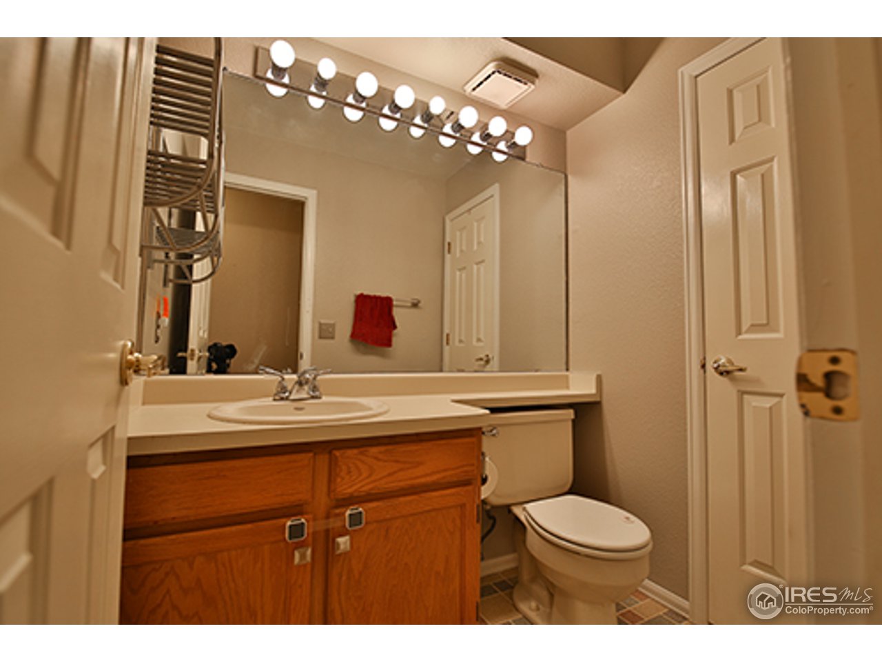 2445 Rim Drive Broomfield, CO 80020 - Photo 7 of 13 a bathroom with a toilet a sink and mirror