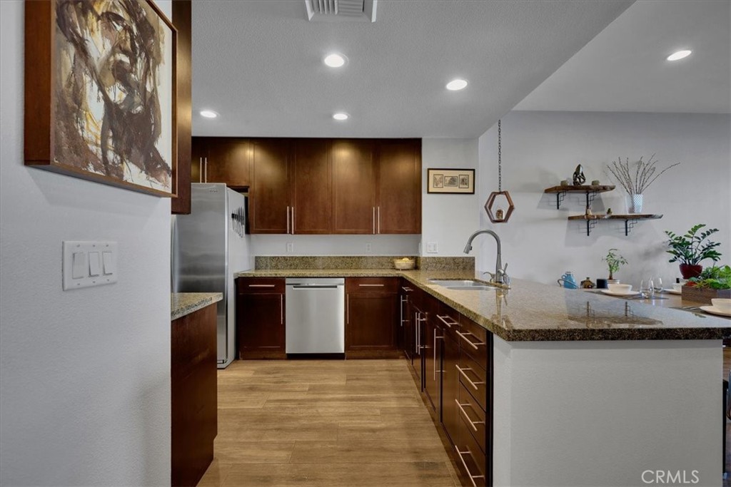 300 East 4th Street, Unit 214 Long Beach, CA 90802 - Photo 16 of 75 a kitchen with stainless steel appliances granite countertop a sink and stove top oven