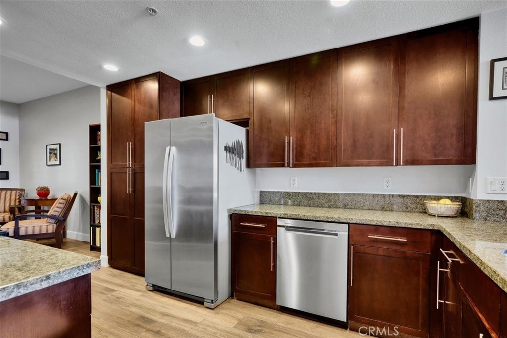 300 East 4th Street, Unit 214 Long Beach, CA 90802 - Photo 17 of 75 a kitchen with stainless steel appliances granite countertop a refrigerator and a sink