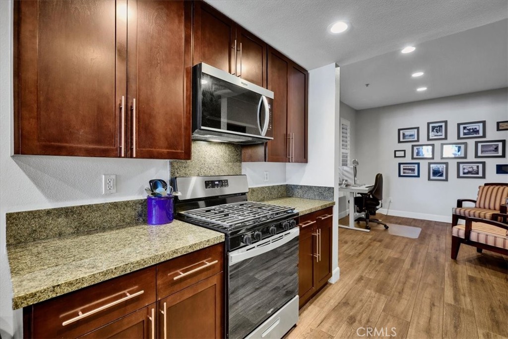 300 East 4th Street, Unit 214 Long Beach, CA 90802 - Photo 21 of 75 a kitchen with granite countertop stainless steel appliances a stove microwave and cabinets