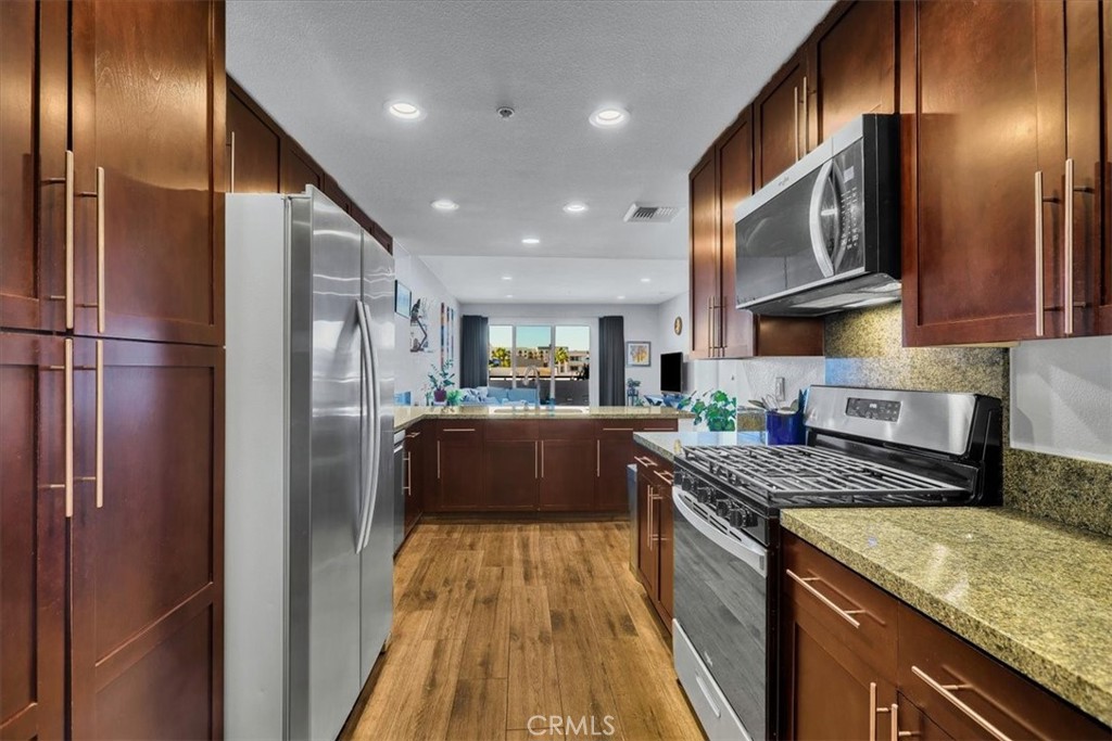 300 East 4th Street, Unit 214 Long Beach, CA 90802 - Photo 22 of 75 a kitchen with stainless steel appliances granite countertop a refrigerator a stove and a sink