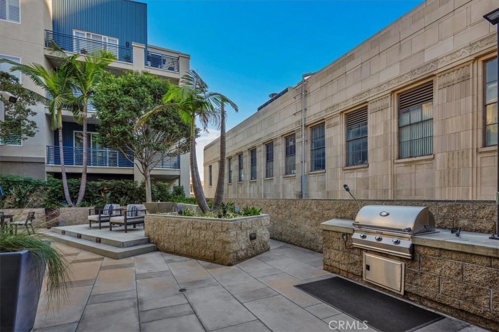 300 East 4th Street, Unit 214 Long Beach, CA 90802 - Photo 59 of 75 a view of a patio with table and chairs potted plants and a large tree