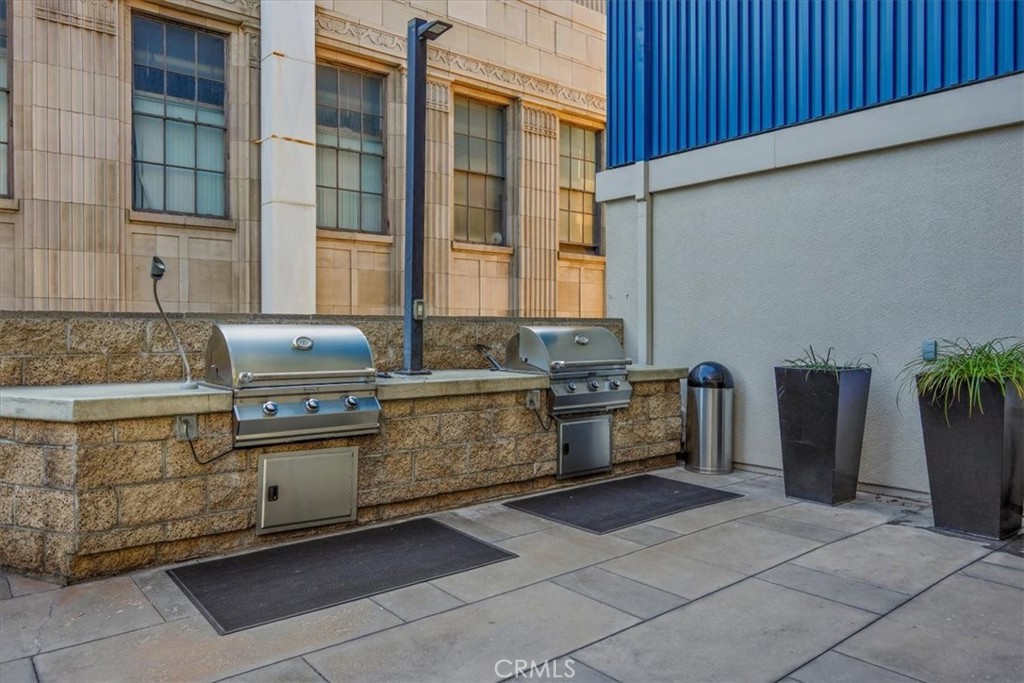 300 East 4th Street, Unit 214 Long Beach, CA 90802 - Photo 61 of 75 a kitchen with stainless steel appliances granite countertop a stove a sink and a microwave