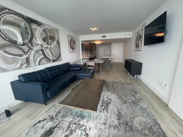 a living room with couches and a flat screen tv