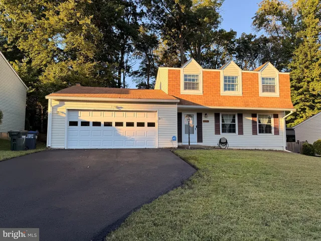 a view of house with yard and trees in the background
