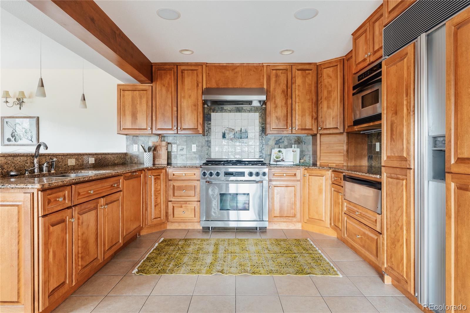 34187 Cactus Drive Evergreen, CO 80439 - Photo 15 of 39 a kitchen with stainless steel appliances granite countertop a stove and a refrigerator