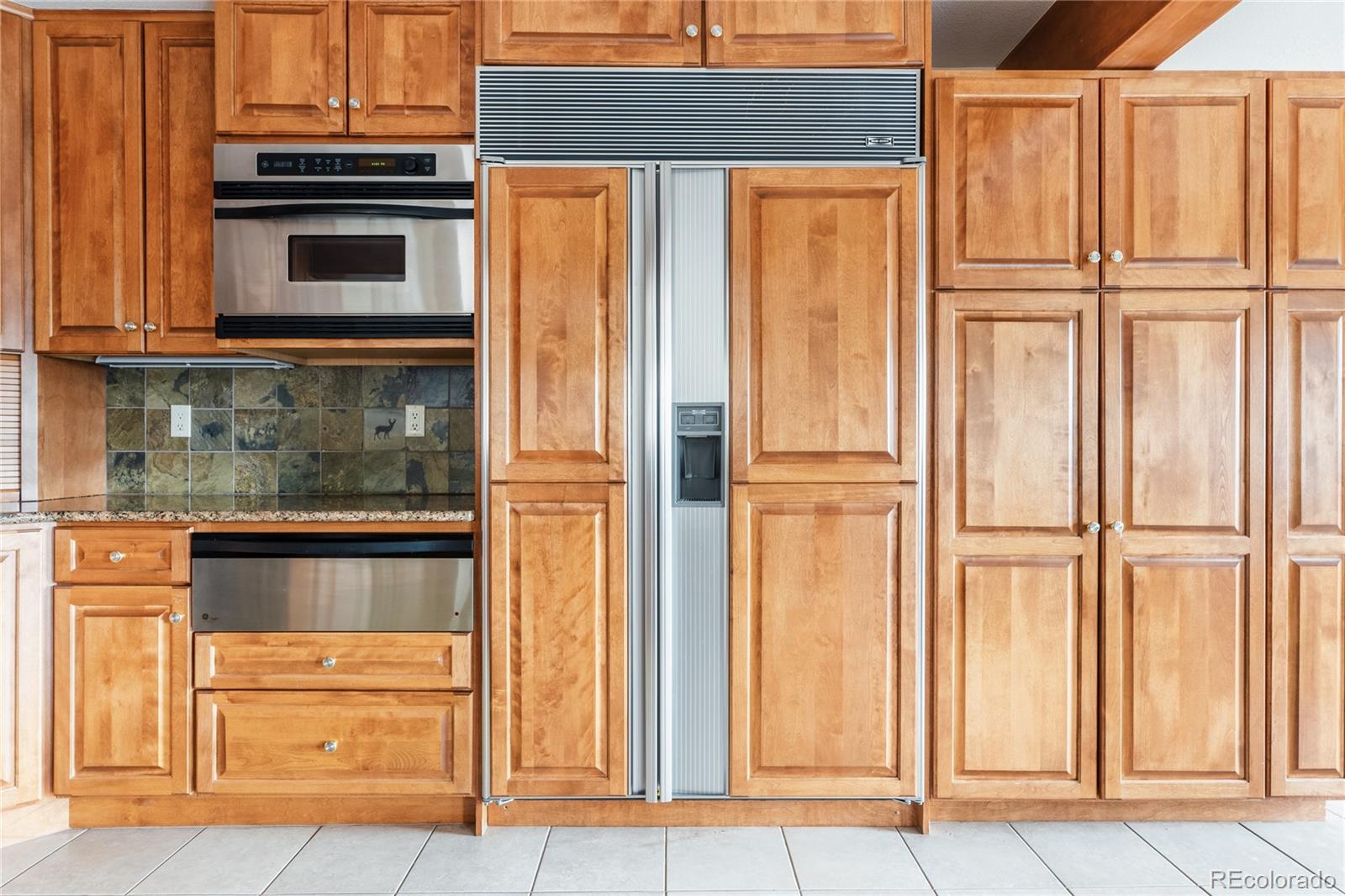 34187 Cactus Drive Evergreen, CO 80439 - Photo 16 of 39 a kitchen with granite countertop cabinets and refrigerator