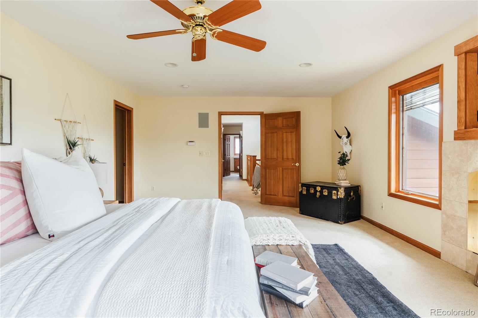 34187 Cactus Drive Evergreen, CO 80439 - Photo 28 of 39 a bedroom with a bed and a chandelier