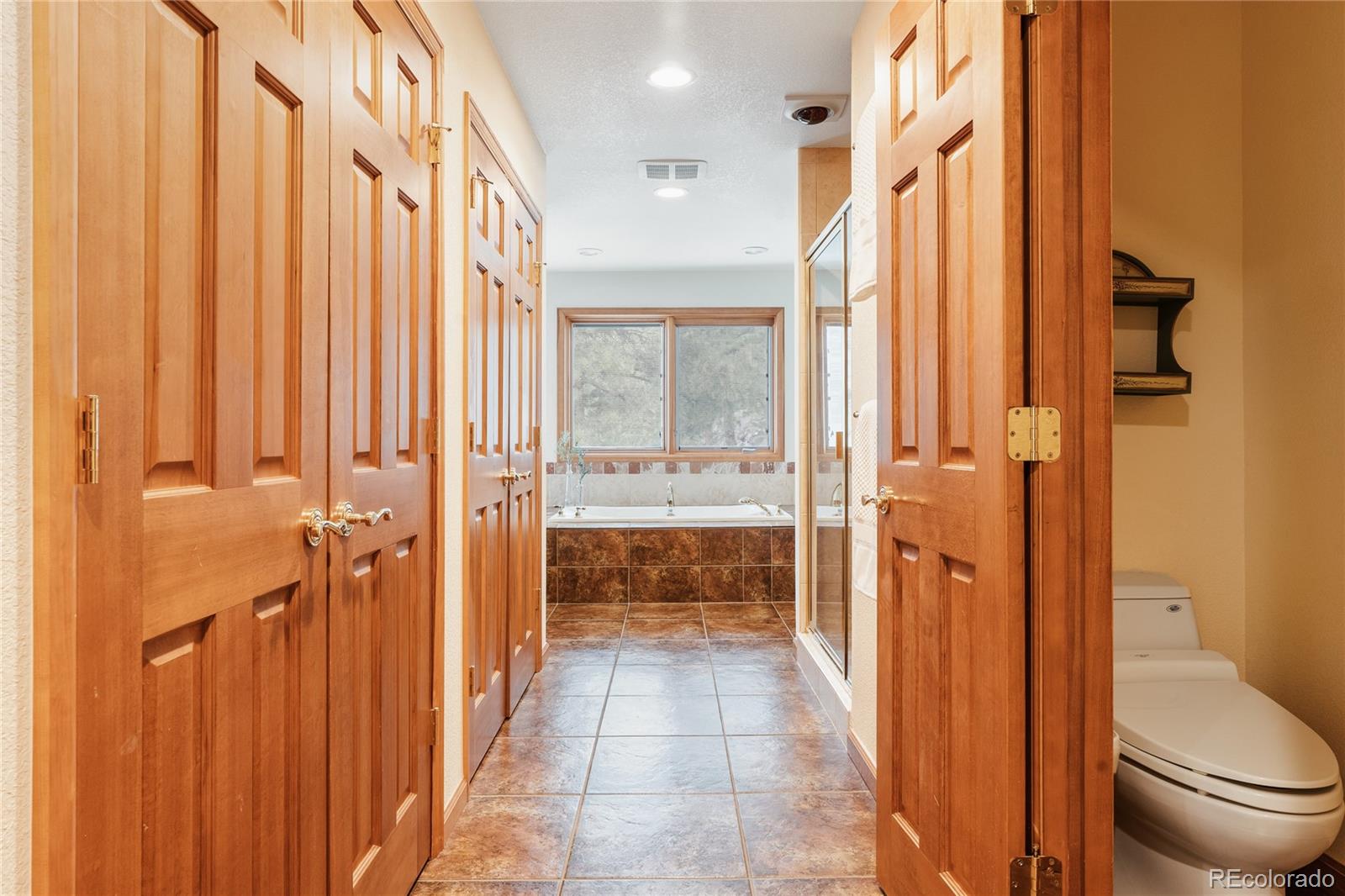 34187 Cactus Drive Evergreen, CO 80439 - Photo 29 of 39 a bathroom with a granite countertop sink a toilet and shower