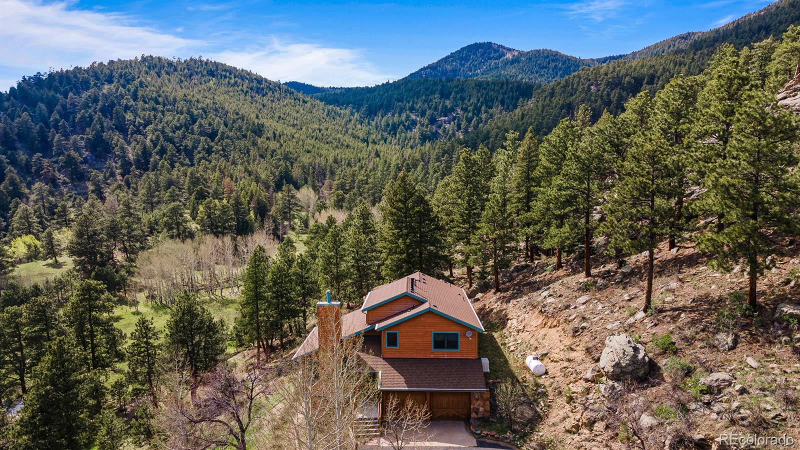 34187 Cactus Drive Evergreen, CO 80439 - Photo 37 of 39 a view of a house with a mountain and a forest