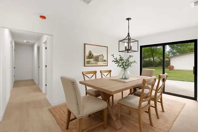 a dining room with furniture a chandelier and window