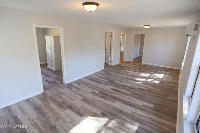 a view of empty room with wooden floor