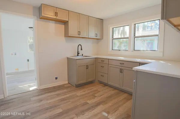 a kitchen with a sink cabinets appliances and a window