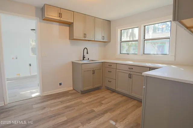 a kitchen with a sink cabinets appliances and a window
