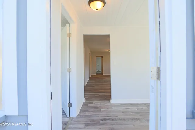 a view of a hallway with wooden floor