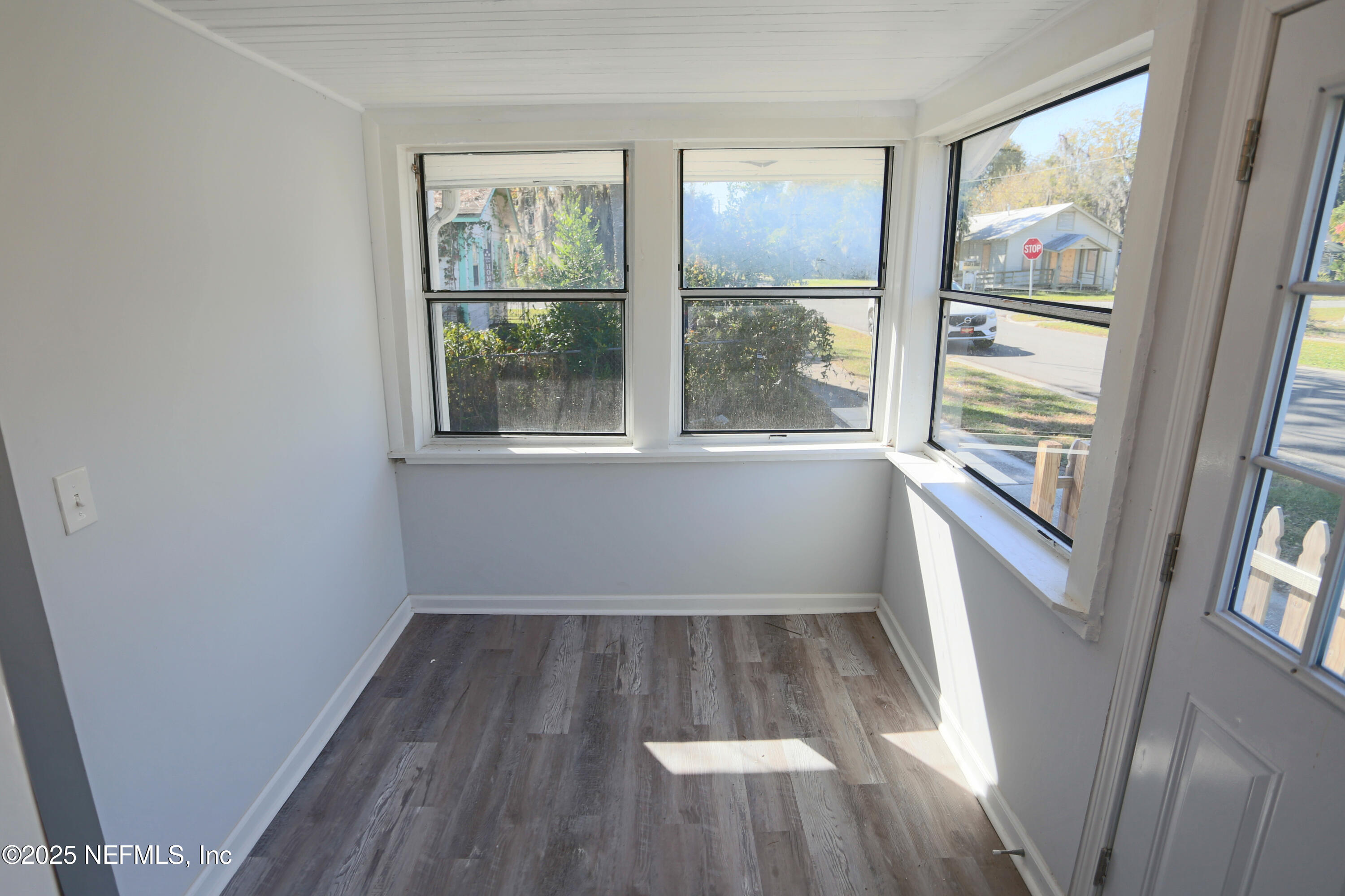 505 North 9th Street Palatka, FL 32177 - Photo 8 of 29 an empty room with wooden floor and windows