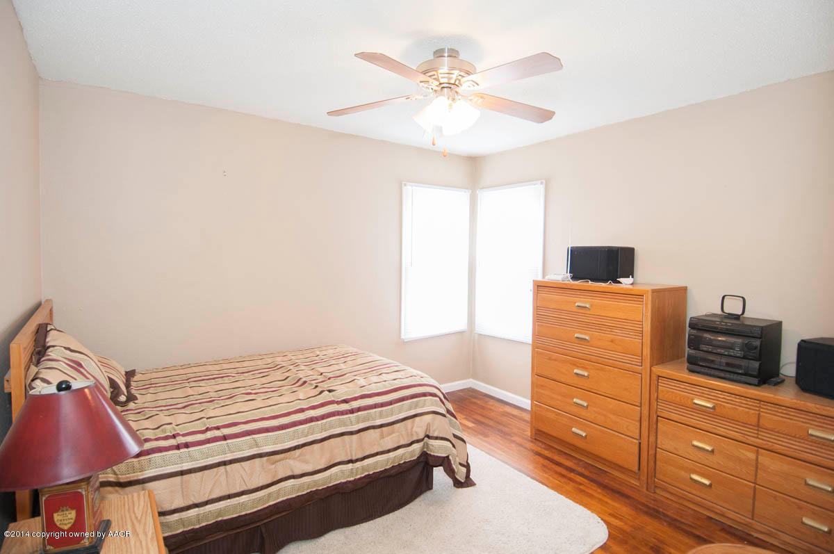 4125 South Ong Street Amarillo, TX 79110 - Photo 10 of 20 a bedroom with a bed and a chandelier
