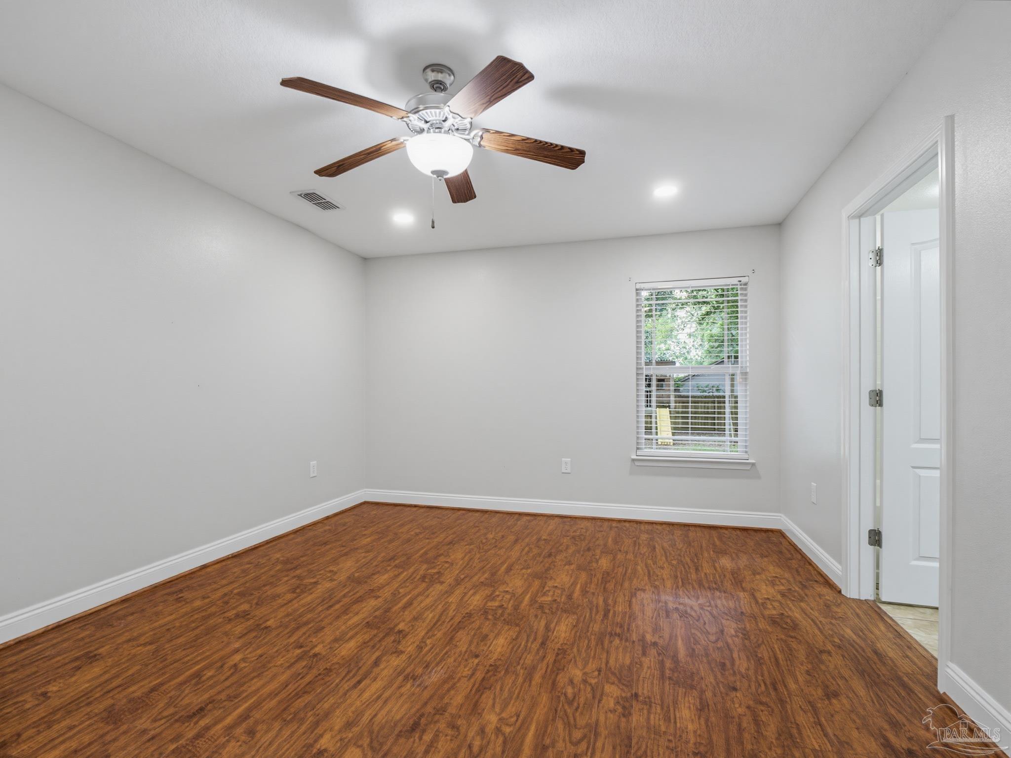 5567 Jones Street Milton, FL 32570 - Photo 26 of 48 an empty room with wooden floor and windows