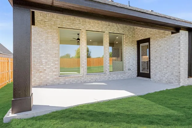 a view of house with a big yard and large trees