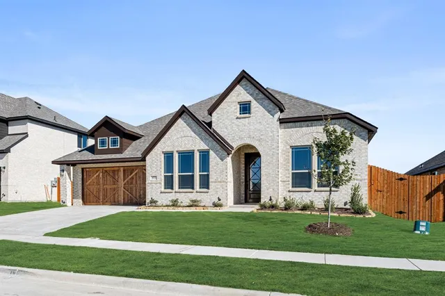 a front view of a house with a garden and yard