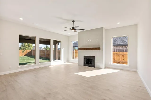 a view of an empty room with a fireplace and a window