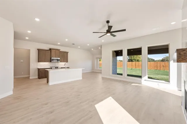 a view of large kitchen with stainless steel appliances kitchen island a sink a stove and a refrigerator