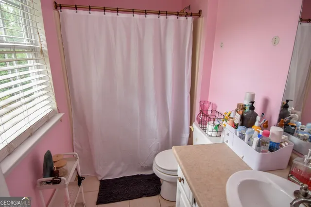 a bathroom with a sink toilet and shower curtain
