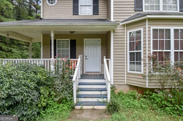 a view of a house with potted plants and a floor to ceiling window