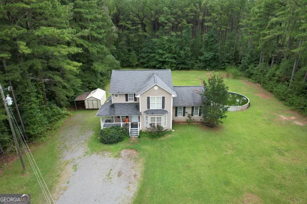 a view of a house with a yard and large tree