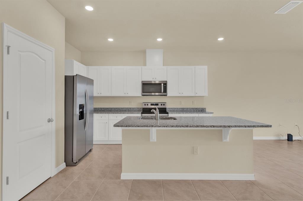 1238 Lido Drive Howey-in-the-Hills, FL 34737 - Photo 13 of 27 a kitchen with stainless steel appliances granite countertop a sink and a refrigerator