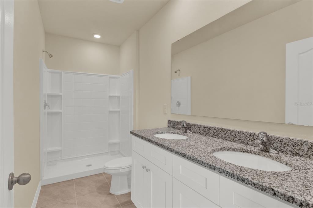 1238 Lido Drive Howey-in-the-Hills, FL 34737 - Photo 19 of 27 a bathroom with a granite countertop sink a toilet and shower