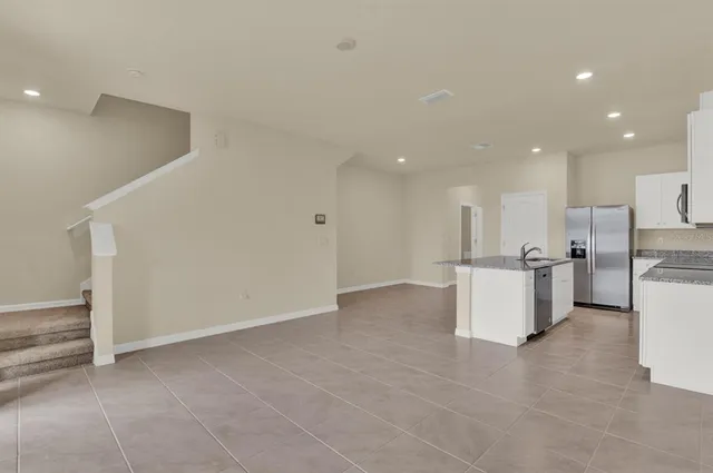 a view of kitchen with kitchen island and stainless steel appliances