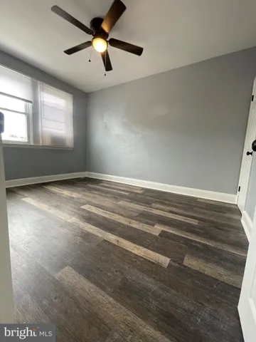 a view of empty room with window and ceiling fan