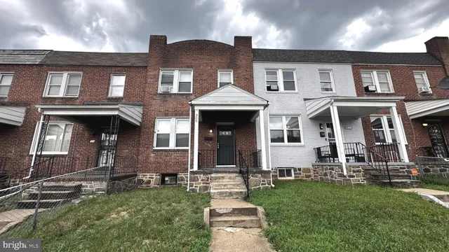 front view of a brick house with a yard