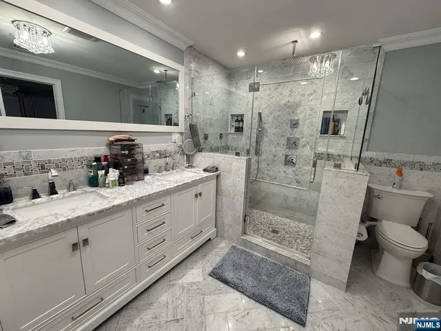 a bathroom with a double vanity sink toilet and shower
