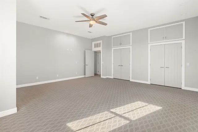 an empty room with closet and ceiling fan