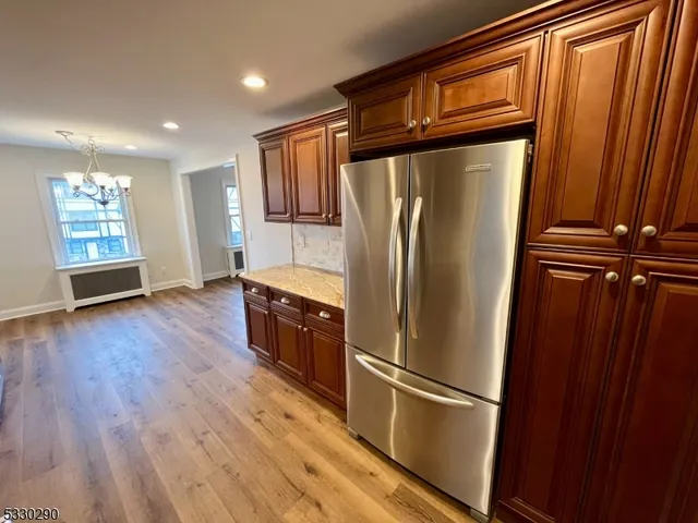 a kitchen with stainless steel appliances a refrigerator and wooden floor