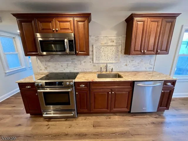 a kitchen with stainless steel appliances granite countertop a stove a sink and a microwave