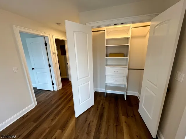 a view of walk in closet with wooden floor and stairs