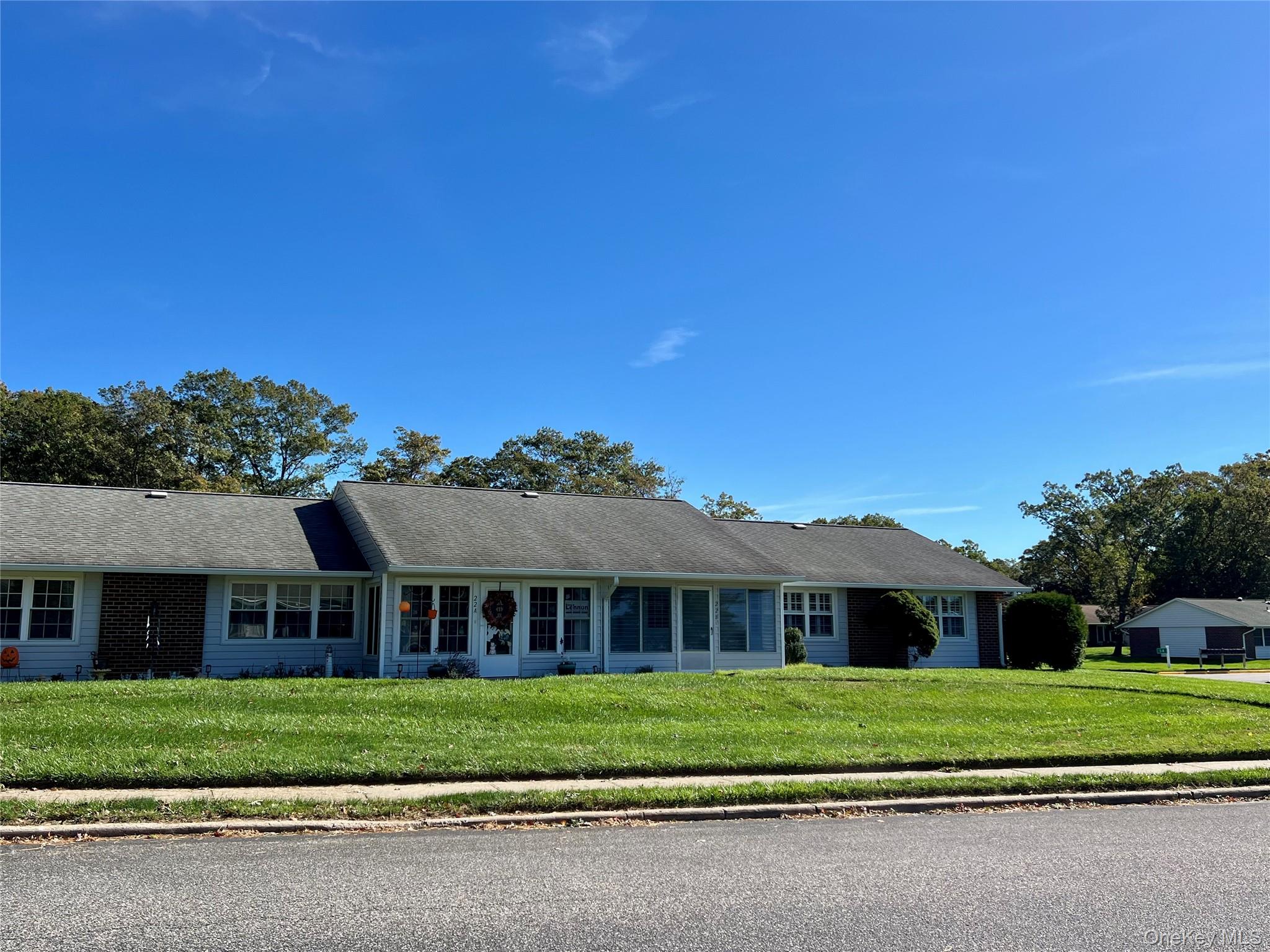 Ranch-style house featuring a front yard and a shingled roof