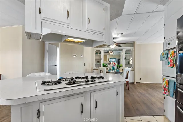 a kitchen with stainless steel appliances granite countertop a stove and white cabinets