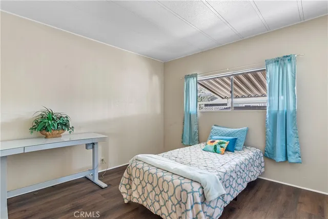 a kitchen with stainless steel appliances kitchen island granite countertop a refrigerator a stove a sink dishwasher and white cabinets with wooden floor