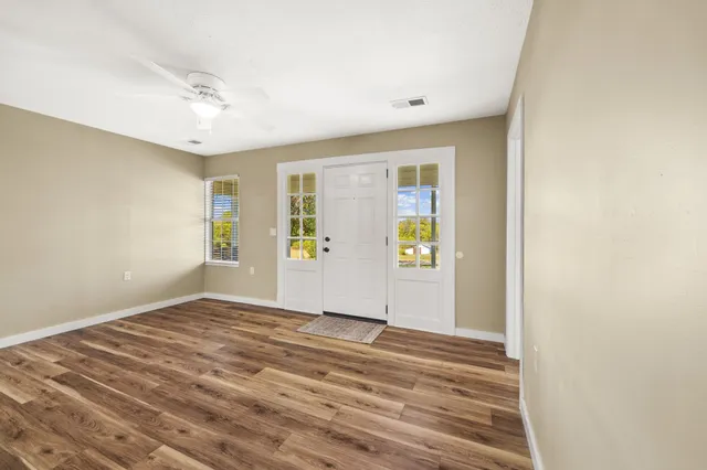 a bedroom with a large bed chandelier and a window