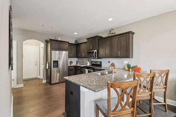 a kitchen with stainless steel appliances granite countertop a refrigerator a stove top oven a sink and dishwasher
