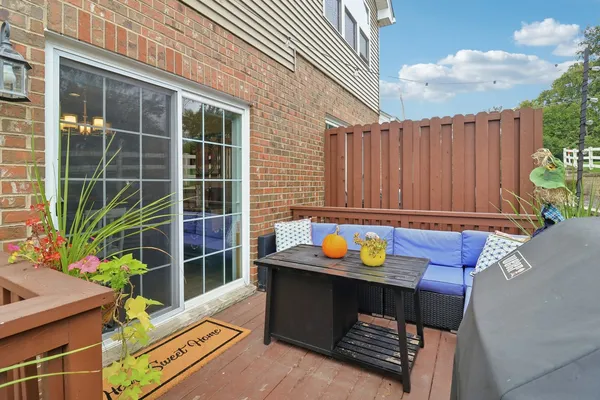 a view of a backyard with chairs and potted plants