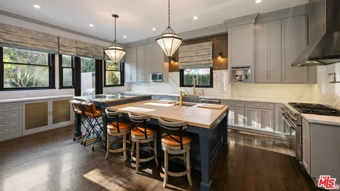 a kitchen with granite countertop a stove a sink and a refrigerator