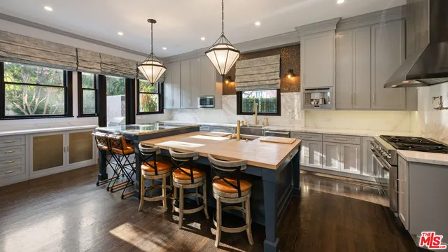 a kitchen with granite countertop a stove a sink and a refrigerator